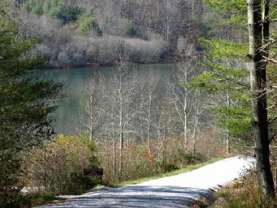 Here, the west fork of the trail crosses this gravel road near the lake.