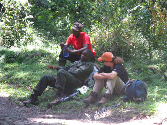 Guide Isaac, Ranger Isaac, and Leigh Ann enjoy a rest on day one of the trek up Mt. Meru .
