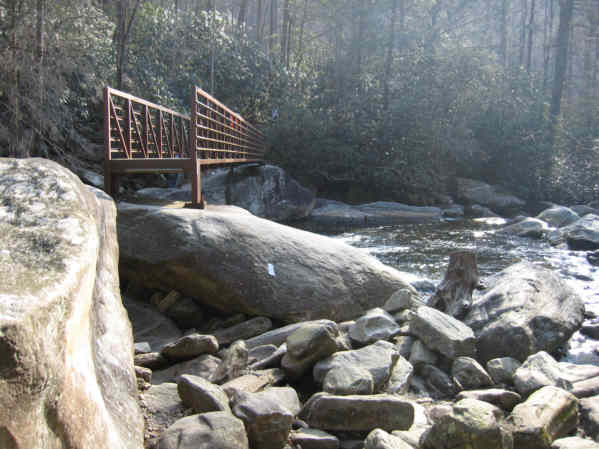 Huge boulders and the iron footbridge at the river crossing.