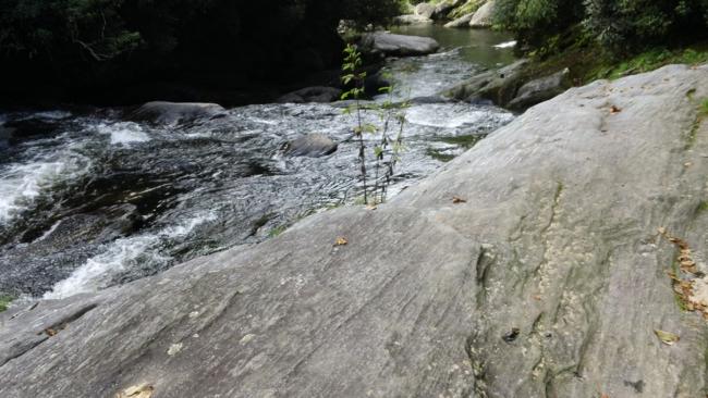 The river flows through the massive rock boulders and ledges.