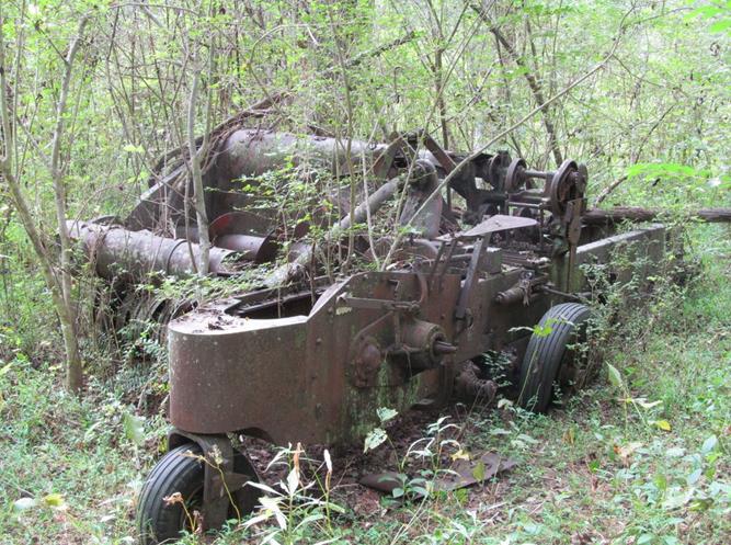 The old abandoned hay baler near a farm homesite on the river. I940's.