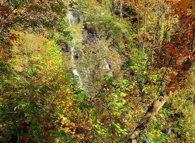 Issaqueena Falls view is partially obstructed by trees.