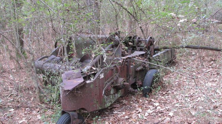 We pass by the old hay baler in the old abandoned farm community.
