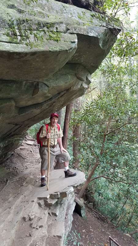 Here, the trail passes under this huge rock ledge .